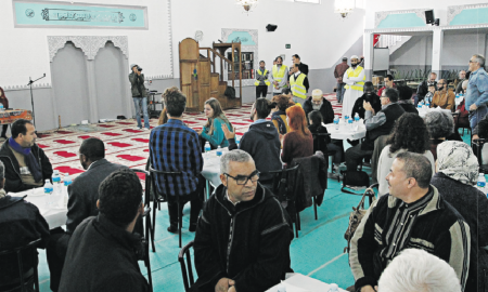 Asistentes a la comida organizada en la mezquita de Ar-risalah