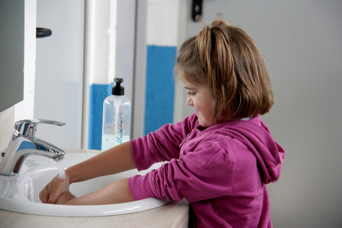 Una nena en un casal d’estiu rentant-se les mans / Albert Lijarcio (ACN)