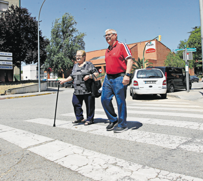 El president de l’associació de veïns de Torre-romeu, Manuel Moya creuant amb una veïna la cruïlla del carrer Sau